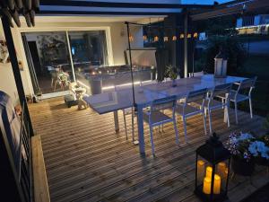 a table and chairs on a deck at night at chambres de La Maillette in Locminé