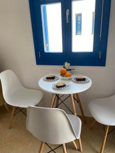 a table with two chairs and two plates of food on it at Casa Ariadne in Náxos