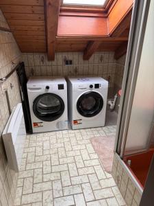 a washing machine and a washer in a bathroom at Cozy Attic in Berkach