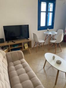 a living room with a couch and a flat screen tv at Casa Ariadne in Náxos