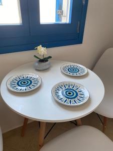 three blue and white plates on a white table at Casa Ariadne in Náxos +25 photos