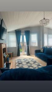 a living room with blue furniture and blue curtains at ocean view 15 in West Down +14 photos