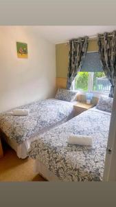 two beds in a room with a window at ocean view 15 in West Down