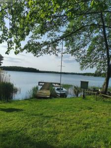 a boat tied up to a dock on a lake at Studio au Fil de l'eau in Langatte