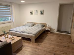 a bedroom with a bed and a table and a window at Ferienwohnung Ulsteraue in Geisa