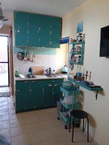 a kitchen with green cabinets and a sink at gialos house in Livadia +16 photos