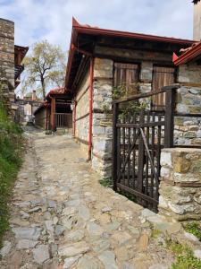 an entrance to a stone building with a gate at Olympia Cozy House in Palaios Panteleimonas