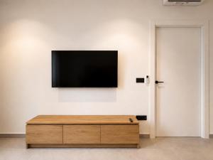 a flat screen tv hanging on a white wall at OMO STAYS Pinada Park in Guardamar del Segura