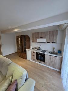 a living room with a couch and a kitchen at Lily 1 in Ljubuški