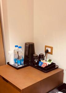 a tray with bottles of water and a coffee maker at Hosta Inn Hotel and Resort in Edappāl