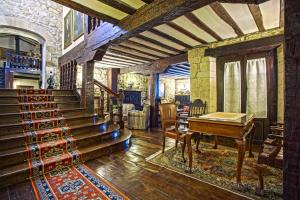 a living room with a staircase and a piano at Hotel Altamira in Santillana del Mar