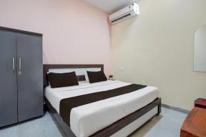 a bedroom with a bed with white and black sheets at HOTEL O STAR INN in Raipur +70 photos