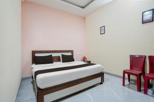 a bedroom with a bed and two red chairs at HOTEL O STAR INN in Raipur