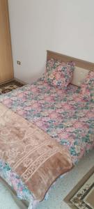 a bed with a quilt on it in a room at Appartement 24 in Sousse