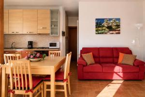 a living room with a table and a red couch at Apartment Alex 2 in Domaso in Domaso