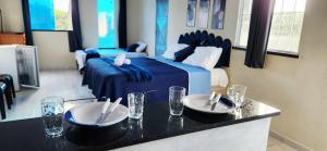 a room with a bed and two plates on a counter at Mini Apartamentos na entrada de Tutóia in Tutóia