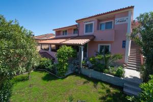 a pink house with a garden in front of it at Apartments Anita in Pula