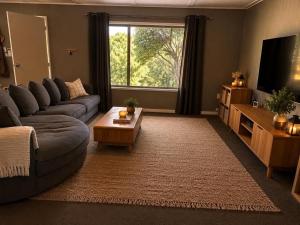 a living room with a couch and a tv at The Cove - Lake Eildon in Piries