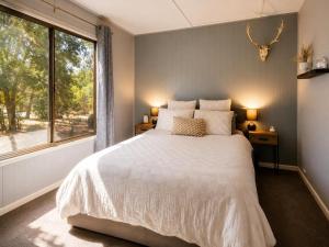 a bedroom with a large bed and a window at The Cove - Lake Eildon in Piries
