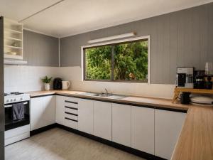 a kitchen with white cabinets and a window at The Cove - Lake Eildon in Piries