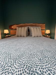 a bedroom with a large bed with two pillows at GITE DE MIRAUVILLE in Apremont-la-Forêt