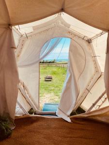 a white tent with a view of a field at Ebb Dome at Estuary Escapes in Kingsbridge