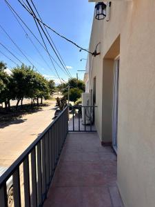 a balcony of a building with a fence and a sidewalk at Apart Boutique EL DESCANSO in Libertador General San Martín