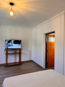 a bedroom with a bed and a flat screen tv at Apart Boutique EL DESCANSO in Libertador General San Martín