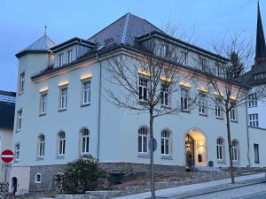 a large white building with a church steeple at Stadtpalais Belle Etage - historische Villa nahe Theater und Soletherme in Bad Elster