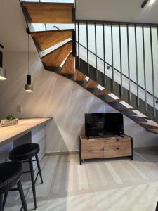 a living room with a tv and a staircase at Almondo Suites in Amigdhaleón