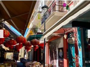 a street with red lanterns hanging from a building at J&B Suites in Kavála