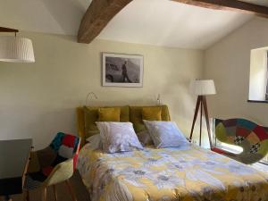 a bedroom with a bed and a lamp and a table at La Villa des Forges in Legé