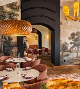 ein Esszimmer mit Tischen und Stühlen und einem Wandgemälde in der Unterkunft Marchanta Riverside Hotel in Santarém