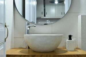 a bathroom with a bowl sink and a mirror at Kastro View Apartment in Plaka Milou +20 photos