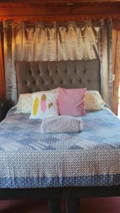 a bed with pillows on it with a head board at Paldoa in Pichilemu