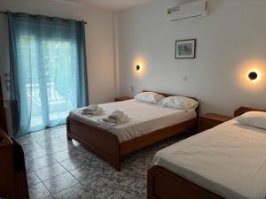 a bedroom with two beds and a window at Indigo sea view rooms in Olympic Beach