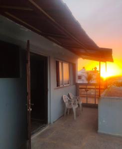 a balcony with a table and chairs and a sunset at Beach House B2 in Kenitra