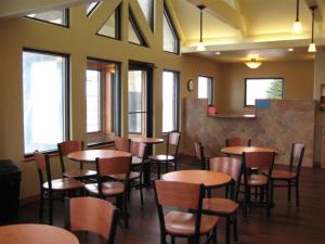 a restaurant with wooden tables and chairs and windows at Trade winds in Valentine