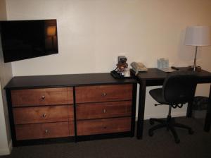 a bedroom with a dresser and a desk with a television at Trade winds in Valentine