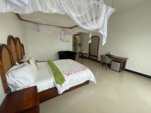 a bedroom with a large white bed with a canopy at Minah bungalows in Nungwi