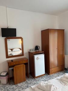 a room with a refrigerator and a dresser and a mirror at Indigo sea view rooms in Olympic Beach