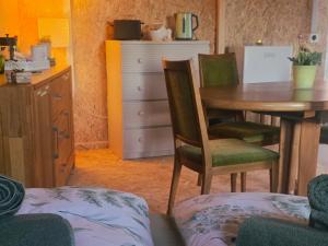 a room with a table and chairs and a kitchen at Cozy Cow Farm Lodge in Lucerne