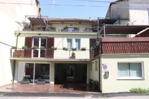 a white building with plants on the balcony at Casa Vacanza del Palio 2 in Nizza Monferrato