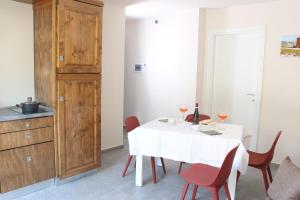 a dining room with a white table and red chairs at Casa Vacanza del Palio 2 in Nizza Monferrato