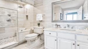 a bathroom with a toilet and a sink and a mirror at Luxury Vacation Escape Free Beach Service Come Relax Book Now! in Panama City Beach