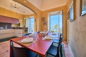 a dining room with a red table and chairs at Doretta's House - Luxury Apartment in Noli