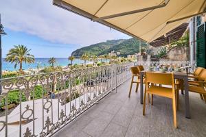 a balcony with a table and chairs and a view of the ocean at Doretta's House - Luxury Apartment in Noli