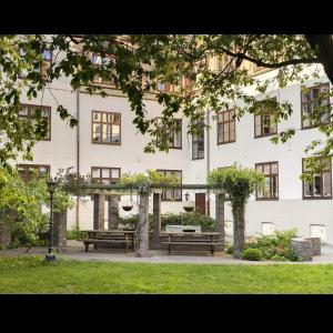 a large white building with benches in front of it at Oslo, Classic Apartment in Oslo