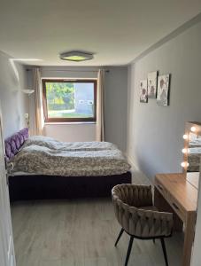 a bedroom with a bed and a window and a chair at Szlachcianka in Gorzuchów
