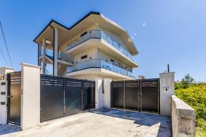 a house with a gate in front of it at Crystal Beach Rooms by PS in Durrës